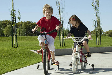 boy and girl riding bicycles with training wheels